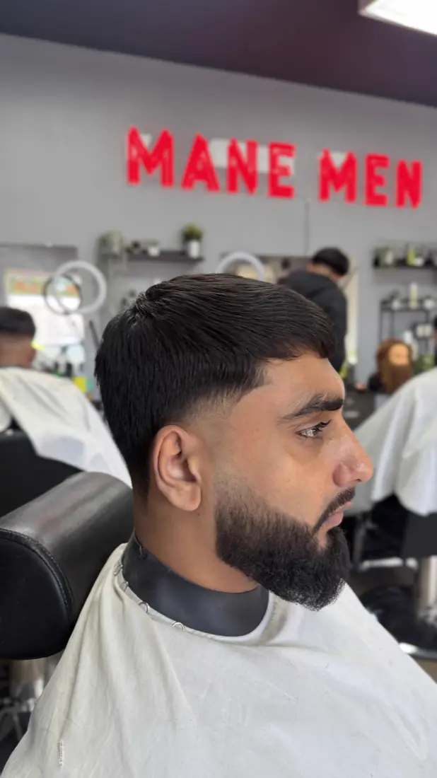 Low fade with a sharp beard line-up
