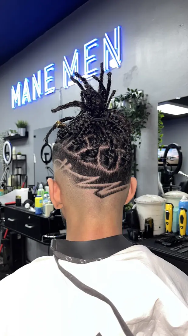 Braids with a lightning-bolt design shaved into a fade